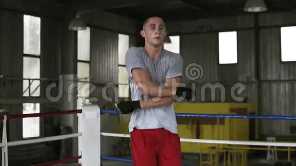 一位英俊的年轻白种人运动员在拳击场锻炼时正用跳绳跳着做交叉动作视频的预览图