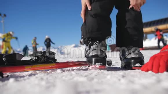 在一个阳光明媚的早晨滑雪者穿着滑雪靴走进滑雪板修理滑雪靴近距离滑雪视频的预览图