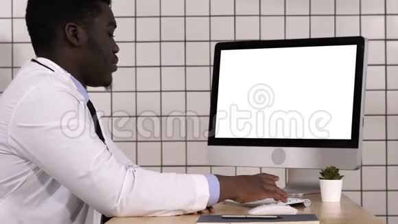 非洲医生用他的电脑打视频电话白色显示器视频的预览图