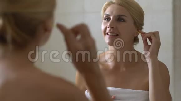 在卫生间用棉签清洁耳朵的女人耳朵卫生医疗保健视频的预览图