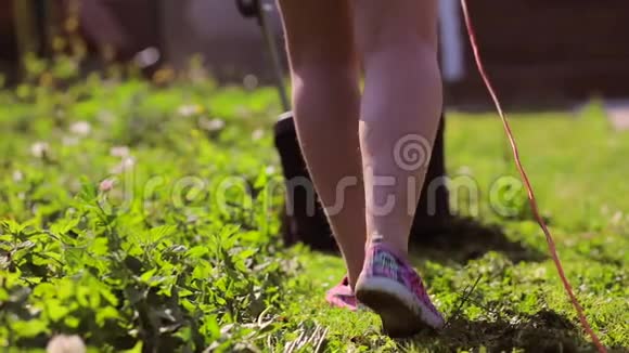 女人用电动割草机剪花园视频的预览图