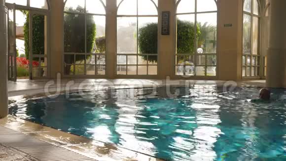 运动员在游泳池游泳在度假酒店从水中出来视频的预览图