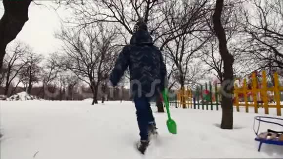 高清开朗的男孩正和孩子们在雪地里铲子走开视频的预览图
