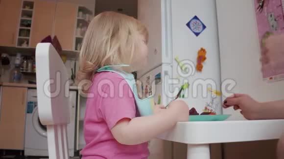 两岁的金发碧眼小女孩在吃饭4K镜头视频的预览图