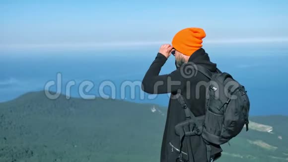 戴着帽子戴着墨镜欣赏蓝天大海的男潮汐游客视频的预览图