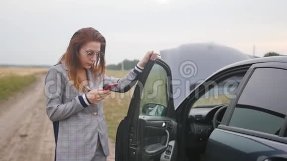 年轻女子因为汽车故障而心烦意乱红发女子不知道车坏的原因汽车视频的预览图