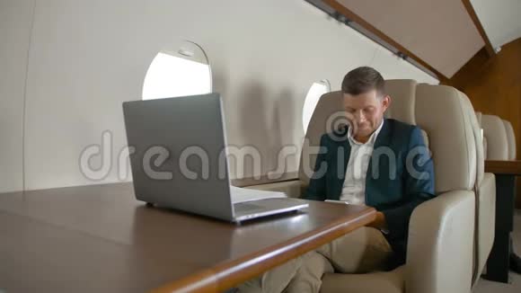 商人在私人飞机上坐在扶手椅上聊天视频的预览图