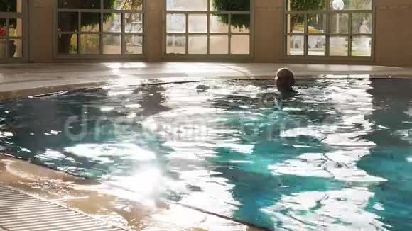 有魅力的男人在游泳池里游泳竖起大拇指视频的预览图