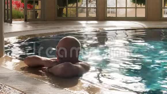 快乐的男人在游泳池游泳享受豪华别墅的休息视频的预览图