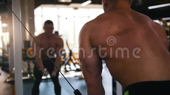 裸胸健美运动员在镜子前的健身房进行有线飞行锻炼视频的预览图