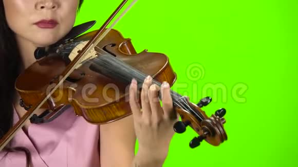 用棕色小提琴弹奏琴弦的女孩快关门绿色屏幕视频的预览图