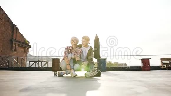 朋友们在户外坐在滑板上玩得很开心年轻的时髦情侣玩得很开心视频的预览图