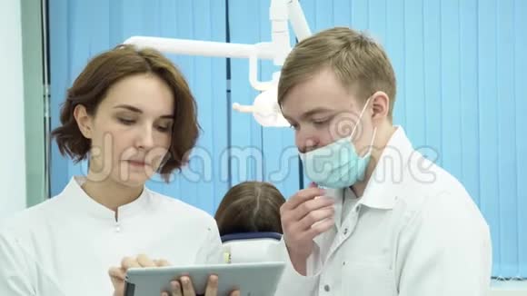 男性牙医和女性助理讨论病人的诊断媒体男女牙医争论病人的测试视频的预览图