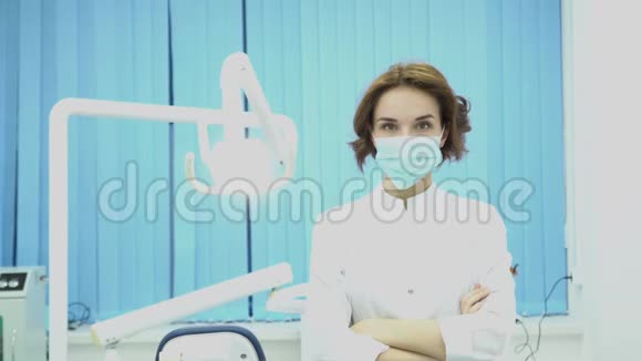 女牙医在牙科办公室戴面具媒体戴口罩和白大褂的漂亮女牙医准备工作视频的预览图