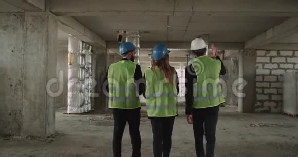 三位工程师或建筑师穿过大楼进行讨论视频的预览图