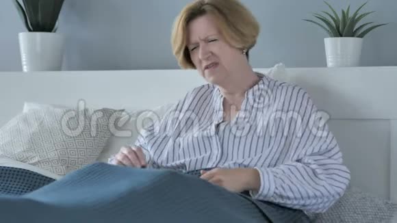 坐在床上背疼的老年妇女视频的预览图