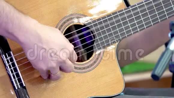 在舞台上演奏经典吉他的男人的手视频的预览图