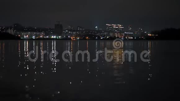 加速运动河流两岸的夜间城市景观视频的预览图