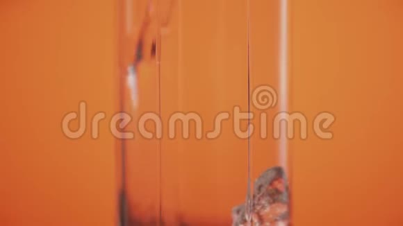 在玻璃橙色背景下倒入苏打水清爽地喝干净的苏打水视频的预览图