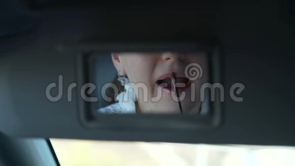 迷人的女人在车镜里的唇彩视频的预览图