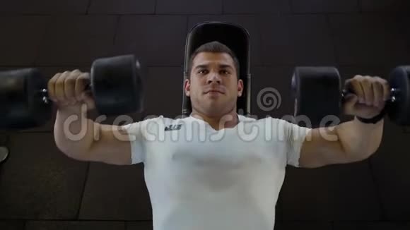 强壮的男人在健身房用哑铃做运动视频的预览图
