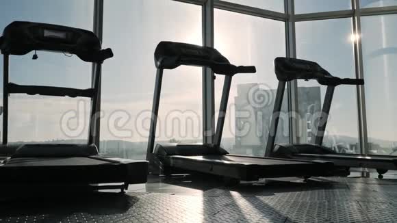 大窗户附近运动健身房跑步机的视野视频的预览图