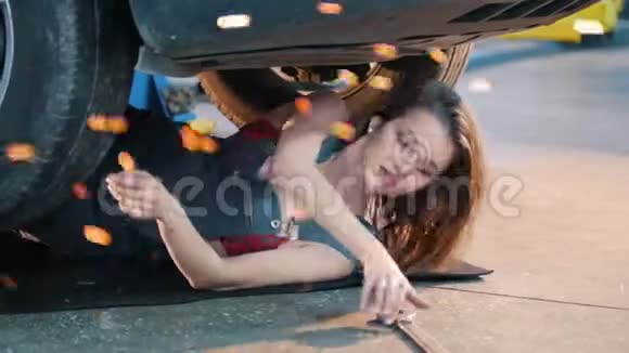 性感的机械师女孩躺在车下伸手抓住扳手燃烧的雪花视频的预览图