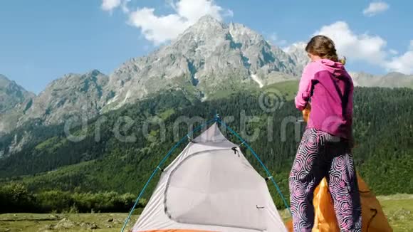 快乐的旅游女孩在山上搭帐篷放松视频的预览图