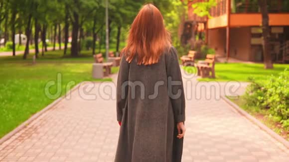 后景穿灰色外套的女商人在春城慢动作散步视频的预览图