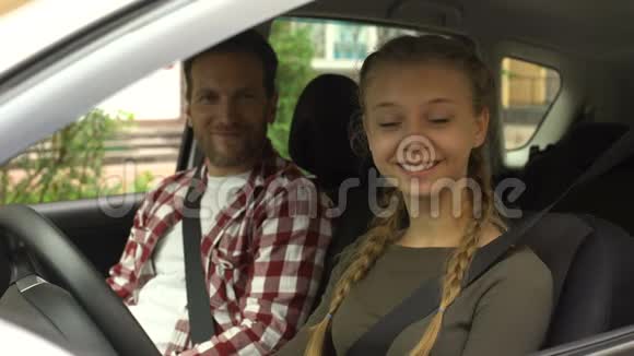 快乐的女孩子笑成了镜头和教练坐在车里在驾校视频的预览图