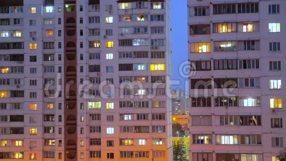 夜间有照明的建筑窗户人们住在有阳台的公寓里电力视频的预览图