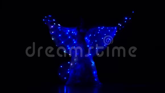 肚皮舞女舞着两只发光的翅膀黑色背景西瓦特慢动作视频的预览图