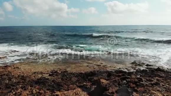 海浪拍打岩石悬崖海滩的空中拍摄波涛汹涌的海浪冲击着岩石海滩无人驾驶视频的预览图