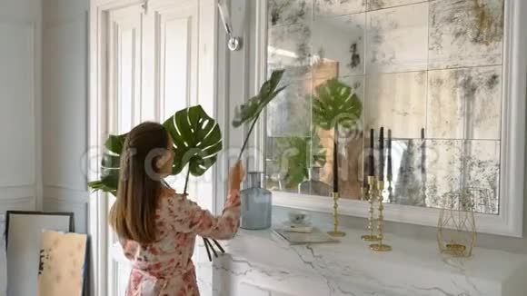 美丽的家庭主妇把花瓶里的叶子放进去视频的预览图