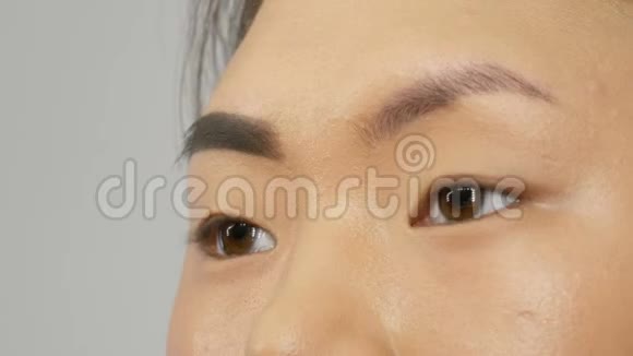 专业造型师化妆师用特殊的画笔描绘眉毛眉毛阴影为亚洲女孩模特的脸视频的预览图
