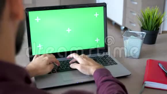 揭露商人在家打字和用绿色屏幕模拟的笔记本电脑工作的镜头视频的预览图