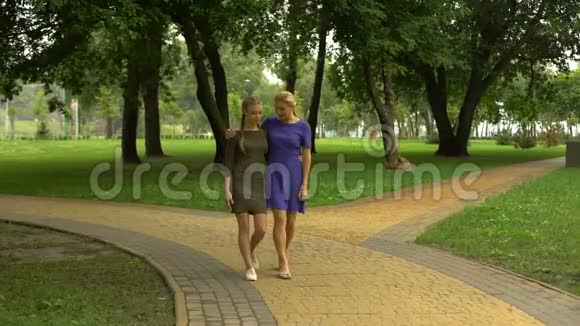母女俩在公园边散步谈笑风生一起消遣视频的预览图