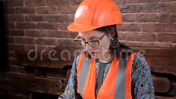年轻女工程师做工作笔记特殊制服和头盔视频的预览图