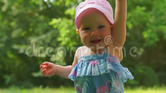 一个婴儿在绿树的背景下笑着视频的预览图