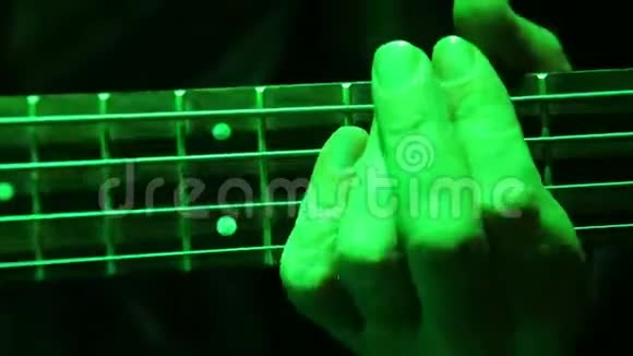 一个男人的特写他用低音吉他弹奏和弦视频的预览图