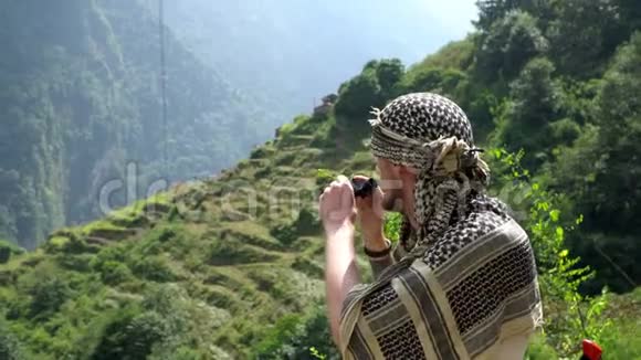 徒步旅行者通过双筒望远镜在一条跋涉小径上寻找到安纳普尔纳大本营喜马拉雅山尼泊尔视频的预览图