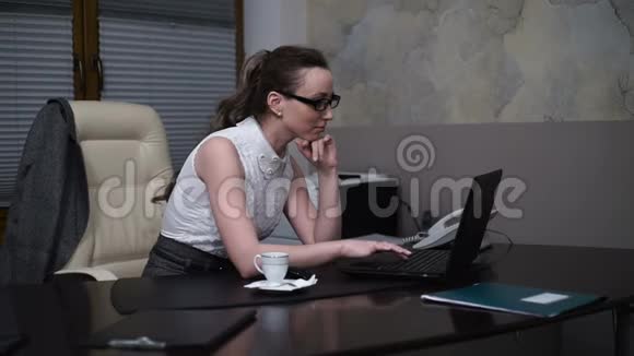 女秘书在办公室喝咖啡休息时用手提电脑工作视频的预览图