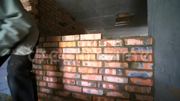 建筑工人把砖头放好一名建筑工人正在铺设砖墙视频的预览图