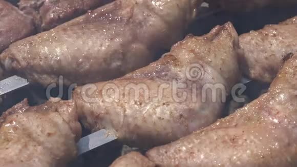 户外炭火烧烤架上的金属串烧成美味可口的鸡肉烧烤视频的预览图
