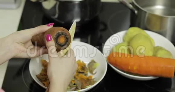 女家庭主妇在厨房里用手剥胡萝卜视频的预览图