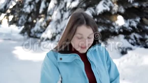 一个年轻的女孩在森林里的冬天散步为照相机摆姿势视频的预览图