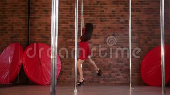 穿红色裙子跳舞的女孩跳钢管舞从杆子上下来朝摄像机走去视频的预览图