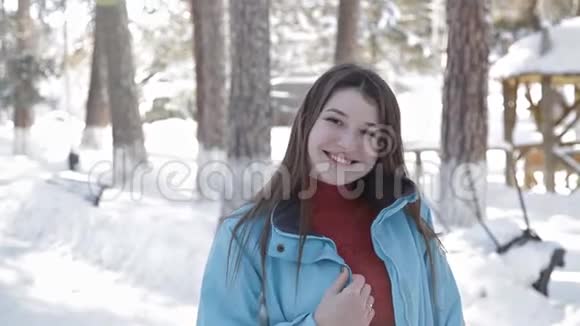 一个年轻的女孩在森林里的冬天散步为照相机摆姿势视频的预览图