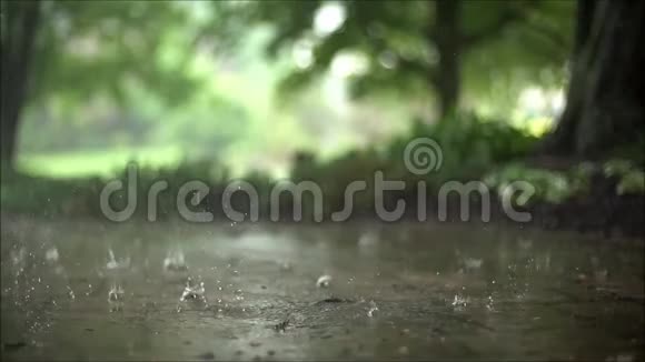 令人着迷的近距离稳定的令人满意的慢镜头倾盆大雨落在路面沥青混凝土道路上视频的预览图