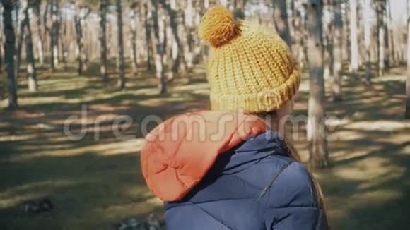 穿着帽子和夹克在森林里的少女松树视频的预览图